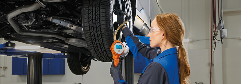 A Subaru technician checking tire pressure. | Doral Subaru in Doral FL