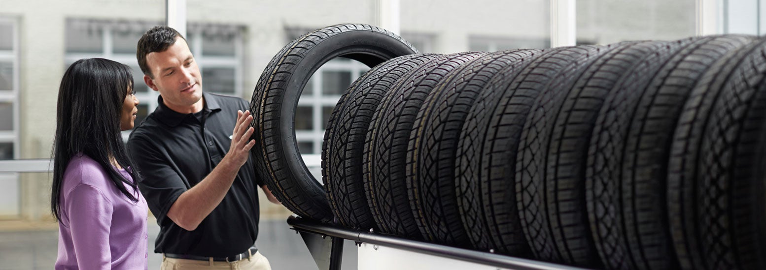 Subaru service representative showing customer a tire. | Doral Subaru in Doral FL